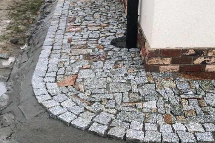 Układanie kostki granitowej z naturalnego kamienia granitowego na ścieżkach dookoła domu