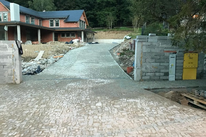 Układanie kostki granitowej z naturalnego kamienia granitowego na nachylonym podjeździe