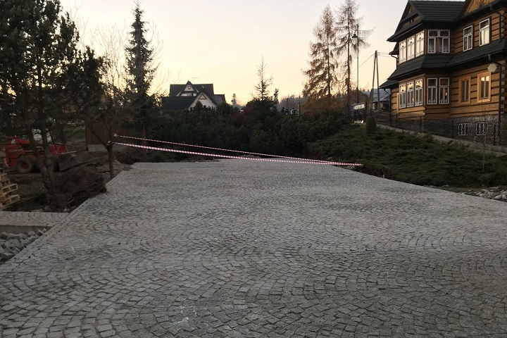 Układanie kostki granitowej z naturalnego kamienia granitowego na parkingu