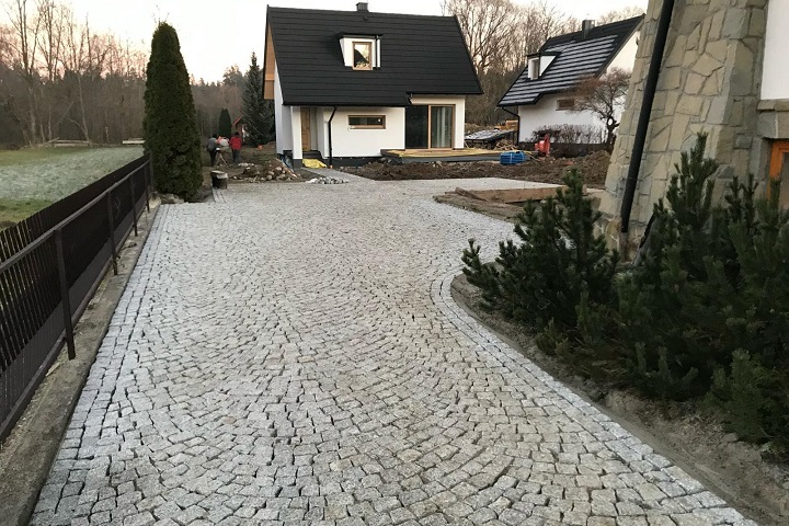 Układanie kostki granitowej z naturalnego kamienia granitowego na podjeździe
