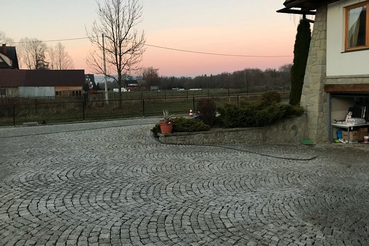 Układanie kostki granitowej z naturalnego kamienia granitowego na podjeździe i placu