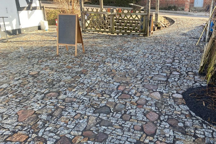 Parking wykonany z nieregularnej kolorowej kostki granitowej i naturalnego kamienia.